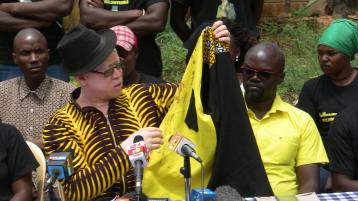 Nominated MP Isaac Mwaura showing journalists the bloody shirt he was wearing when the assassination attempt was made.